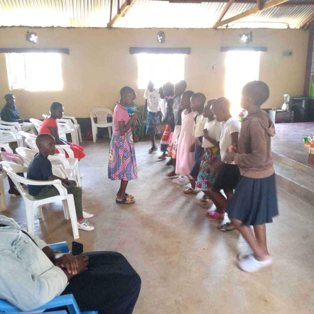 Children and adults gathered inside a community hall.