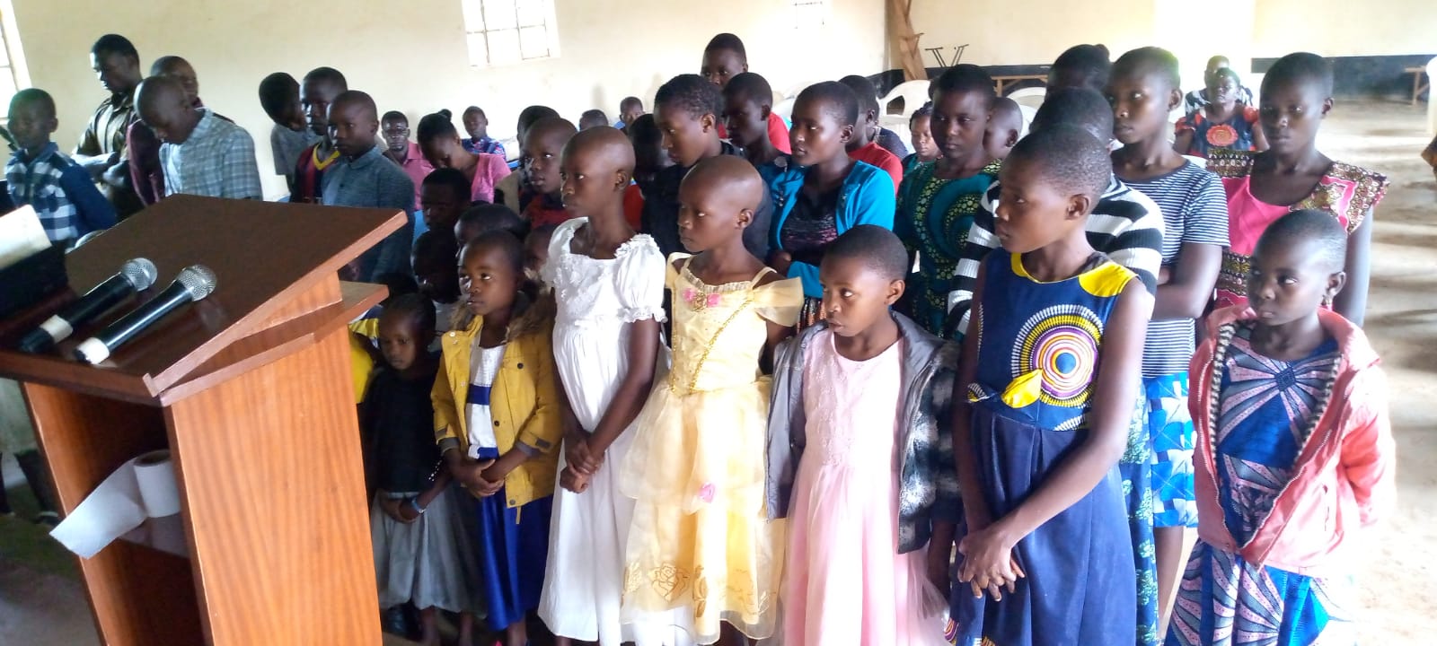 Children and adults gathered inside a community hall.